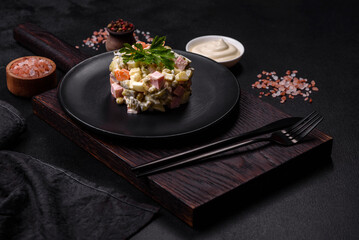 Delicious fresh Olivier salad with sausage, egg, cucumber, green peas, carrots and mayonnaise