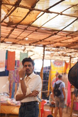 Obraz na płótnie Canvas man wearing yellow shirt posing in flea market
