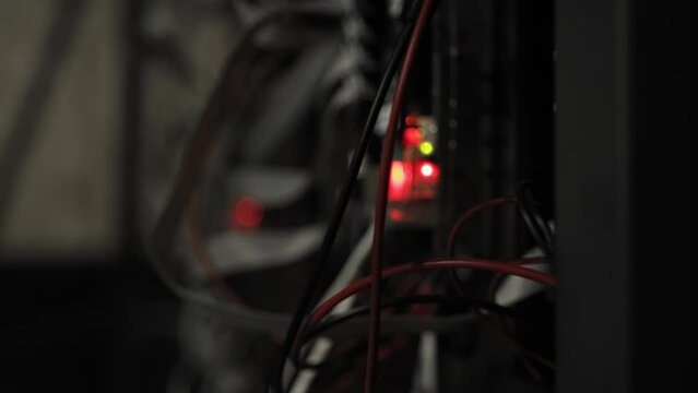 Cables, wires in dark room, closeup. Green light is blinking. Complex electronic device. Engine. Reverse back side of led wall screen panels for virtual production. Unreal CG in cinematography. On-set