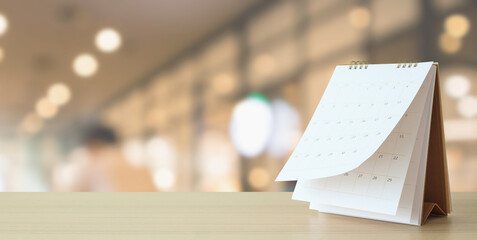 desk calendar on table with blurred bokeh background appointment and business meeting concept