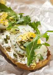 Toast with cream cheese, arugula salad and boiled egg