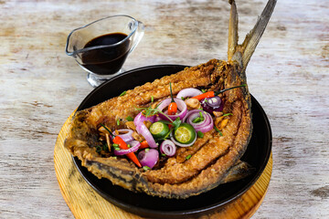 Sizzling Giant Bangus A La Pobre with soya sauce served in a dish isolated on grey background side view - obrazy, fototapety, plakaty