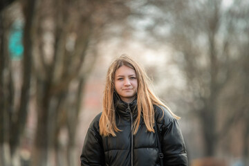 Portrait of a young beautiful blonde girl outdoors in autumn.