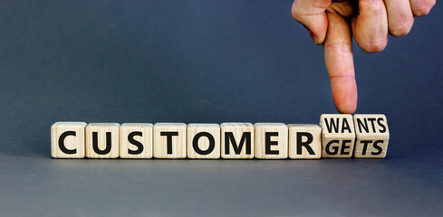 Customer wants and gets symbol. Concept words Customer wants or Customer gets on wooden cubes. Businessman hand. Beautiful grey background. Business customer wants or gets concept. Copy space.