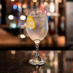 gin tonic cocktail in a wine glass at the bar counter.