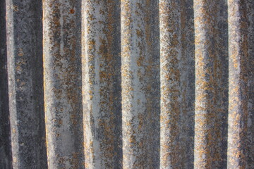 Background of an old asbestos sheet with mold. Corrugated panels, grey slate texture, wavy fence background.