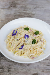 Truffled Mushroom, Bacon, Egg Fettucine pasta noodles served in a dish isolated on grey background side view