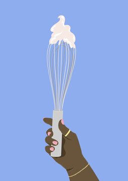 Woman's hand holding up whisk 
