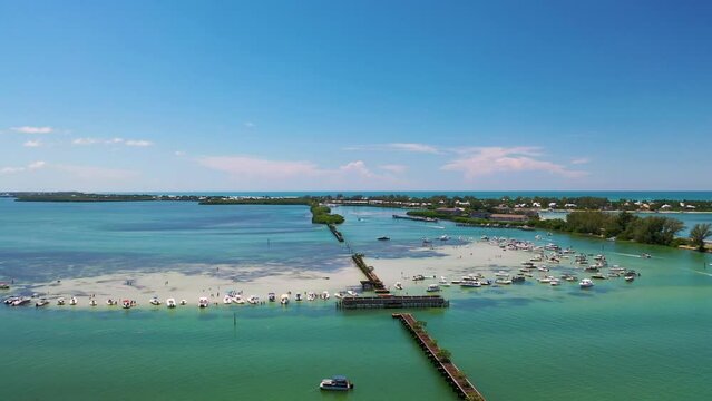 Bright aerial footage of the Boca Sandbar surrounded with boats at Boca Grande, FL
