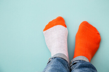 Odd socks day concept. Legs in different socks on a blue background. Top view with copy space.