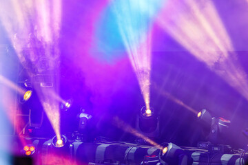 Neon pink and mauve spotlight beams on stage professionally exposed.