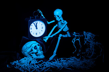 A skeleton waking up, crawling out of the grave and turning off the alarm clock, a skull on a black...