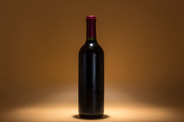 bottle of red wine on a brown background, warmth