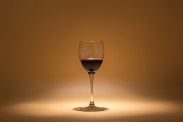 glass of red wine on a warm background created with intimate lighting