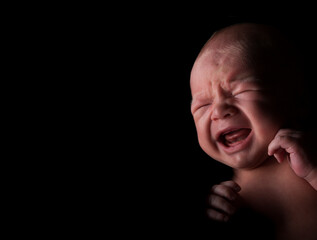 Newborn Caucasian baby crying.