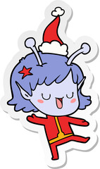 happy alien girl hand drawn sticker cartoon of a wearing santa hat