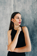 Fototapeta premium Attractive Young Woman Doing Daily Makeup While Standing Near Mirror In Bathroom, Happy Beautiful Female Putting Blush On Cheeks While Getting Ready At Home, Selective Focus On Reflection