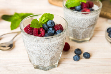 Healthy breakfast or morning with chia seeds vanilla pudding raspberry and blueberry berries on table background, vegetarian food, diet and health concept. Chia pudding with raspberry and blueberry