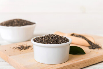 Chia seeds in bowl and spoon on colored background. Healthy Salvia hispanica in small bowl. Healthy superfood