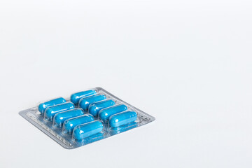 Blister package with Vitamin on color background. Medicine pills on a light background. Medicines and prescription pills flat lay background. blue medical tablets in blister