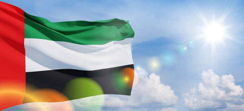 Flag of United Arab Emirates on background of blue sky. UAE celebration. National day, Flag day, Commemoration day, Martyrs day. Banner with place for text.