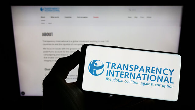 Stuttgart, Germany - 10-02-2022: Person Holding Mobile Phone With Logo Of Association Transparency International E.V. On Screen In Front Of Web Page. Focus On Phone Display.