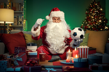 Happy Santa Claus watching soccer on TV