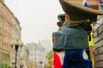 Rows of russian winter hats of different colors with army emblems at the street market at Old Arbat...