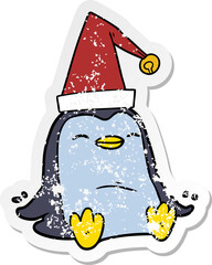 distressed sticker of a cartoon penguin wearing christmas hat