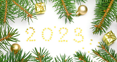 Golden numbers 2023, green Christmas tree branches, gift boxes and Christmas ornaments on white background flat lay.