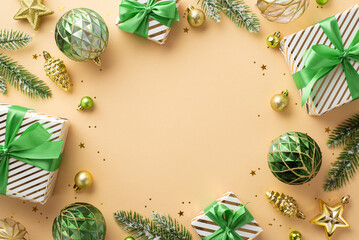 Christmas concept. Top view photo of gift boxes with ribbon bows gold and green baubles pine cone star ornaments fir branches and confetti on isolated beige background with empty space in the middle