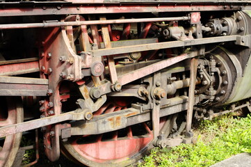Historic railway. Old steam locomotive. A part of the suspension. Wheels and pistons are visible.