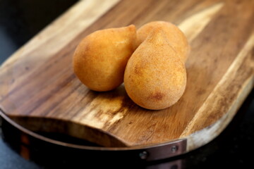 delicious fried chicken drumstick on wooden board. typically Brazilian snack
