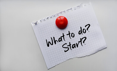 Paper note written with WHAT TO DO. START inscription on cork board
