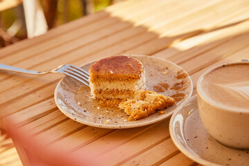 Aesthetic gluten free no baking carrot cake under hard shadows with cup of cappuccino.
