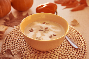 Traditional seasonal fall vegetarian pumpkin cream soup with seeds and plant-based cream.