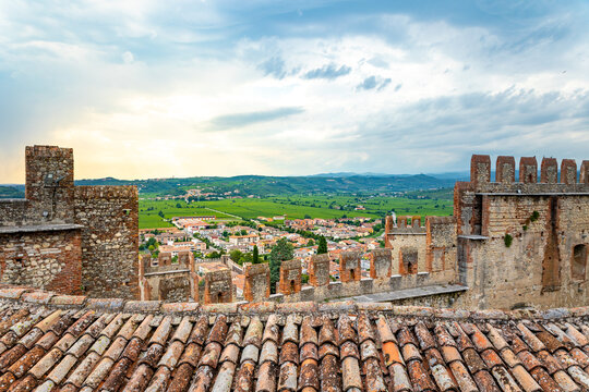 Town of Soave and vineyards from the castle walls of its medieval castle Castello di Soave. View on Mounts Lessini and the Po valley on a cloudy day in Italy.