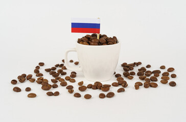 The flag of Russia sticks out of a cup with roasted coffee beans.