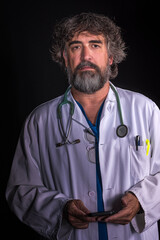 bearded mature doctor dressed in blue operating room suit and white coat