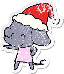 cute hand drawn distressed sticker cartoon of a elephant wearing santa hat