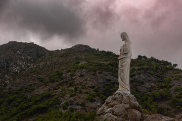 statue of a Christ in Mijas pueblo with mountains skyline in the background