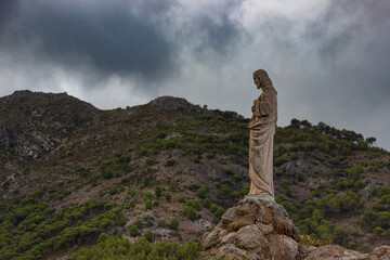 statue of a Christ in Mijas pueblo with mountains skyline in the background