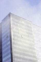 modern glass office building in the city in cold foggy morning