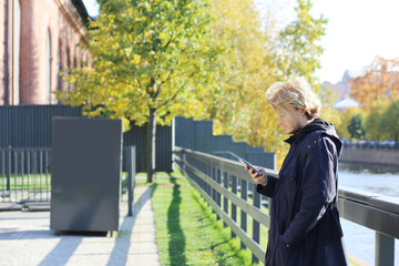 Fototapeta premium Lifestyle portrait of a young man using a smart phone outdoors. man relaxing in autumn park