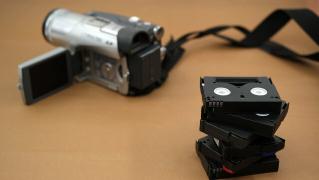 mini dv camera and cassettes, minidv tapes on the brown background