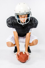 Youth football player bending down to hike the ball