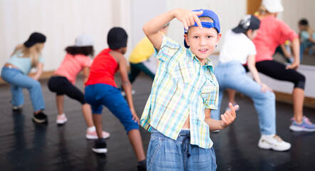 Obraz premium Portrait of boy hip hop dancer exercising with friends at dance class