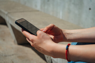 Woman's hands with a cell phone. Copy space. Landscape orientation.