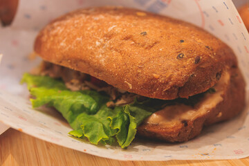 Beautifully decorated catering banquet table on event with different food snacks and appetizers setting with bagel and sandwiches, triange, baguette club submarine sandwich, on a wooden plate