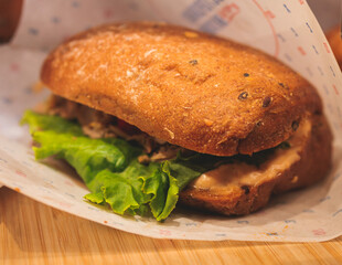 Beautifully decorated catering banquet table on event with different food snacks and appetizers setting with bagel and sandwiches, triange, baguette club submarine sandwich, on a wooden plate